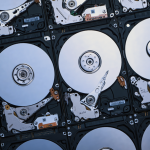 Múltiples discos duros HDD abiertos mostrando platos y actuadores, utilizados como referencia en el análisis sobre rendimiento tipo flash y alto throughput en 2026